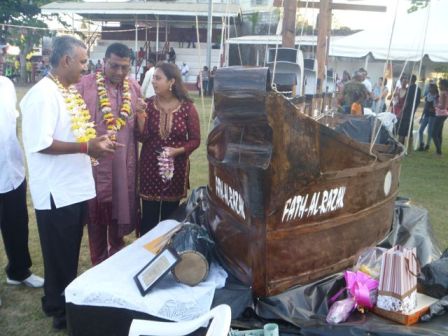 Couva South MP, Rudranath Indarsingh (left), Councillor Allan 'Taxi' Seepersad (2nd from left) and Couva North MP, Ramona Ramdial (right) discuss antique Indo-Trinidadian artifacts and the model of the Fath-al-Razak on display at the Couva Indian Arrival Celebration