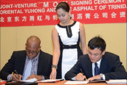 STRONGER TIES: Ashley Taylor, left, chairman of Lake Asphalt of Trinidad and Tobago, and Li Weiguo, chairman of Beijing Oriental Yuhong Waterproof Technology Company Ltd, sign a memorandum of understanding and confidentiality agreement between the companies during a ceremony at the Hyatt Regency (Trinidad), Port of Spain yesterday. Looking on is Lake Asphalt’s corporate secretary Richelle Lyman. —Photo: CURTIS CHASE