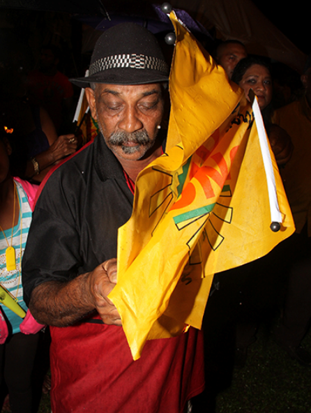 This man torches a UNC flag during the rally in Chaguanas on Friday night.