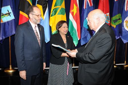 His Excellency José Miguel Insulza presents the report to Prime Minister Persad-Bissessar. Looking is Caricom Secretary General, Irwin LaRocque