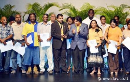 LEASES CEREMONY: Scores of ex-Caroni workers were yesterday presented with their leases. At centre, left is Jairam Seemungal, new Minister of Land and Marine Resources, and at right centre, is Housing Minister Dr. Roodal Moonilal. The ceremony took place at the Naparima Bowl in San Fernando.
