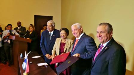 Prime Minister Kamla Persad-Bissessar, SC, MP, holds the Partial Scope Trade Agreement document with Panama's President, Ricardo Martinelli, at the Westin Playa Bonita Hotel in Panama today. Looking on at the Foreign Affairs Ministers, Winston Dookeran, left, of Trinidad and Tobago and Ricardo Jiminez, right, of Panama, who signed the agreement.