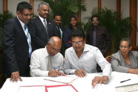 MOUs SIGNING: CEO of Caroni Green, Deosaran Jagroo signs the MOU between Caroni Green and Emunite Energy Solutions, with Ramlagan's General Hardware, Managing Director Krishna Ramlagan. In back row are Minister of Food Production Devant Maharaj; Minister in the Ministry of Finance, Rudy Indarsingh; Daran Soondarsingh, President of Emunite Solutions, Claudia Emmanuel, and CEO of Baron Foods, Ronald Ramjattan. The signing took place yesterday in the Scarlet Ibis Room at Hilton Trinidad. Author: Angello Marcelle