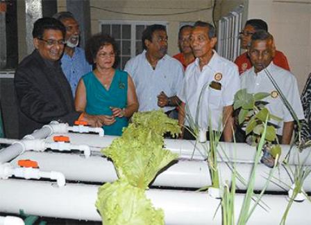 Food Production Minister Devant Maharaj, left, and members of the St Augustine Rotary Club look at the aquaponics system. Photo: Shastri Boodan