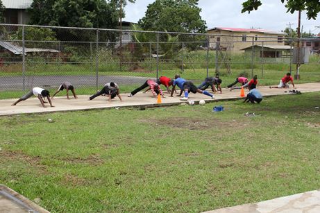 Participants performing stretching exercises during football training at the Bank Village Vacation Camp