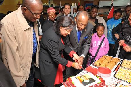 Prime Minister Kamla Persad-Bissessar SC, centre, cuts a special cake made for her during her visit to Conrad's Bakery in Brooklyn, on Thursday night. Looking on at left, is Minister of Community Development, Winston "Gypsy" Peters. PHOTOS COURTESY THE OFFICE OF THE PRIME MINISTER