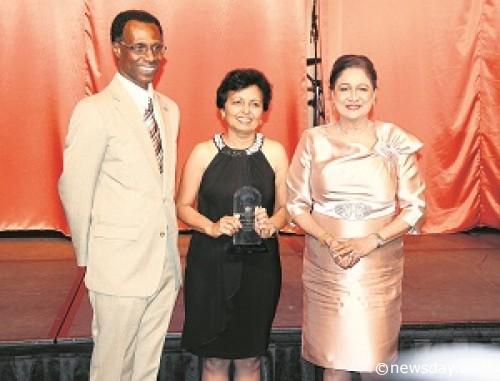 Prime Minister Kamla Persad-Bissessar, right, poses with Head of the Public Service Reynold Cooper after Mohandai Singh Maraj was presented with an award for her 41 years of working in the Public Service. The PM yesterday honoured retirees of the Office of the Prime Minister at the Hyatt Regency, Port-of-Spain.  Author: SUREASH CHOLAI