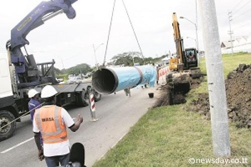 Pipe laying: Water and Sewerage Authority (WASA) workers laying down the first pipeline to mark the start of the Beetham Transmission Pipeline Project at the Beetham Highway on Monday. Author: SUREASH CHOLAI