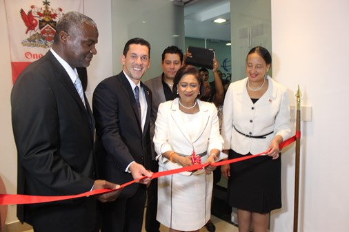 Prime Minister Kamla Persad-Bissessar, second from right, cuts the ribbon to open the new Trinidad and Tobago Embassy in Panama. Looking on from left are, Gerard Greene, Charge D'Affairs at T&T Embassy in Panama, Vice Minister of Foreign Affairs of Panama, Luis Miguel Hincapie, Dr. Neil Parsan, T&T Ambassador Washington DC, and Frances Seignoret, Permanent Secretary, Ministry of Foreign Affairs.