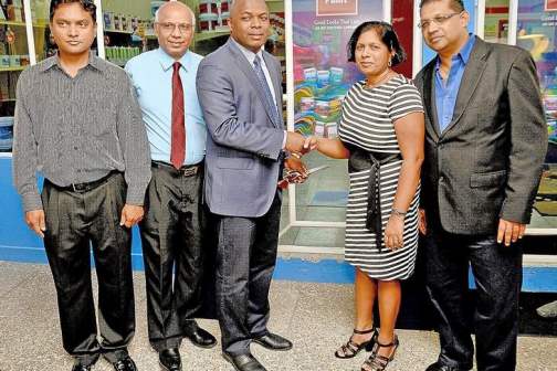 COLOURFUL ENDEAVOUR: Roger Roach, managing director of ANSA Coatings Ltd, centre, greets Micheal Ramsook, right, and his wife during the opening of the new Sissons Colour Shop in Debe on Tuesday. Looking on at left is Shiva Roopnarine, president of the Penal/Debe Chamber of Commerce, and Umanath Maharajh, commercial manager, Sissons Paints. --Photo: DEXTER PHILIP