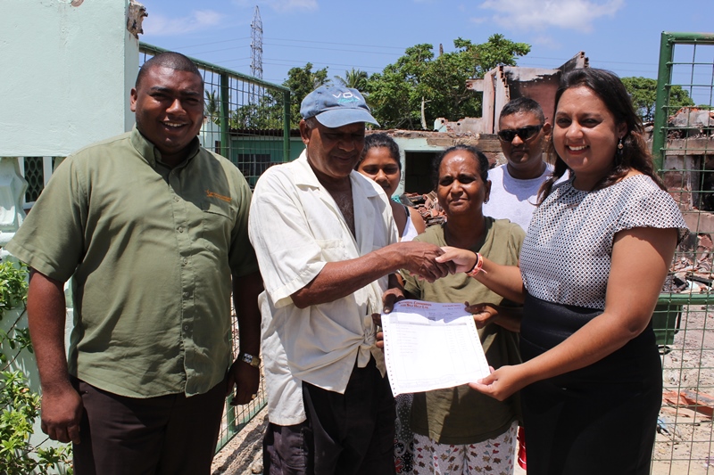  MP Ramona Ramdial (right) presents a Self Help Grant to the Bickharry family whose Brickfield home was recently destroyed by fire